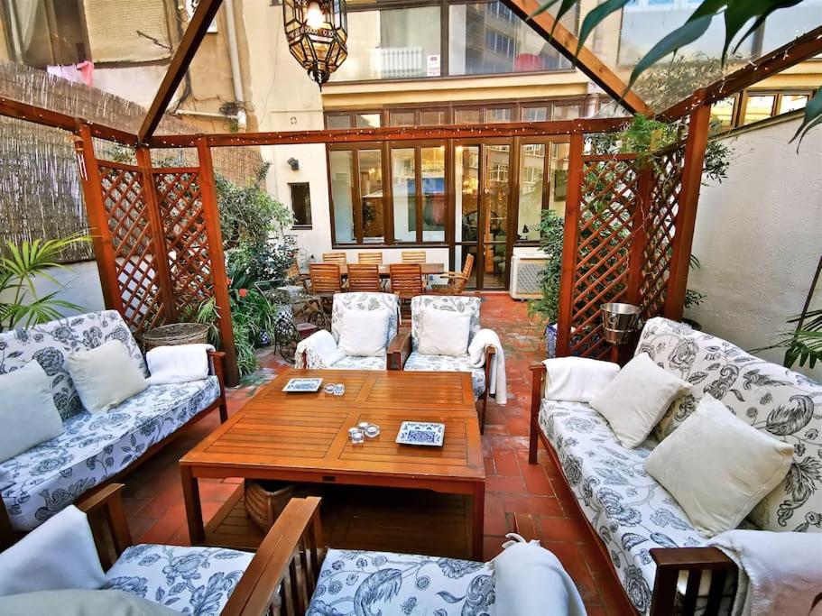 a patio with white couches and a wooden table at Large patio 4 bedrooms 4 bathrooms of which 3 en-suite in Barcelona