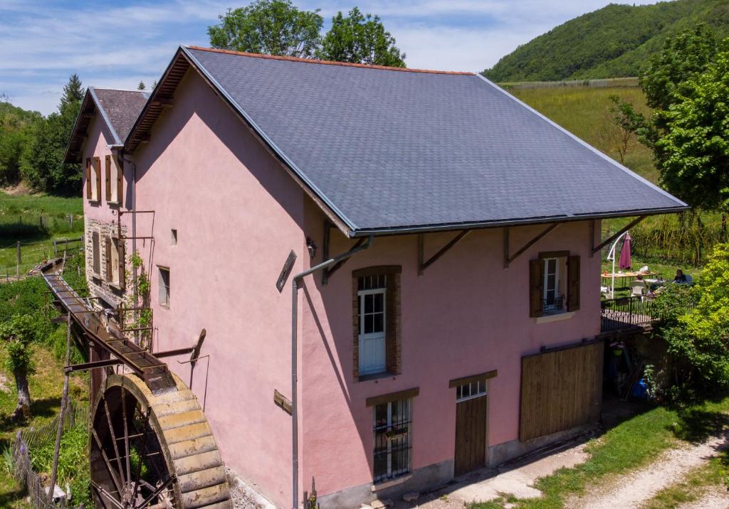 una casa rosa con techo negro en Le Moulin Rose, en Chirens