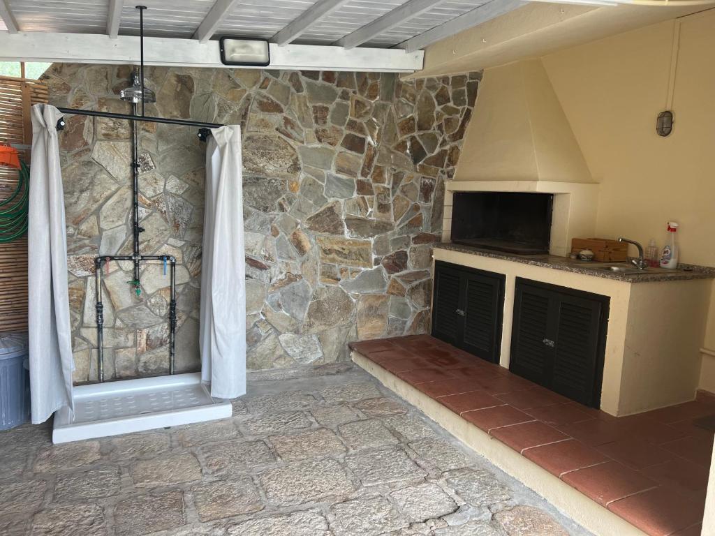 a kitchen with a stone wall and a stove at Villetta Indipendente Sardegna in Villaputzu