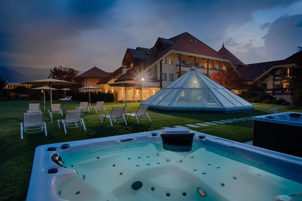 a hot tub in the yard of a house at Schönblick - Sport & Active Hotel in Brunico