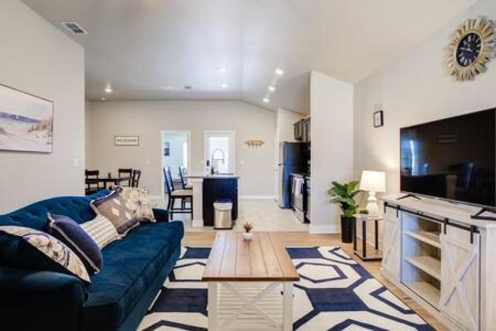 uma sala de estar com um sofá azul e uma mesa em Milano Lodge - Cozy Retreat em Lubbock