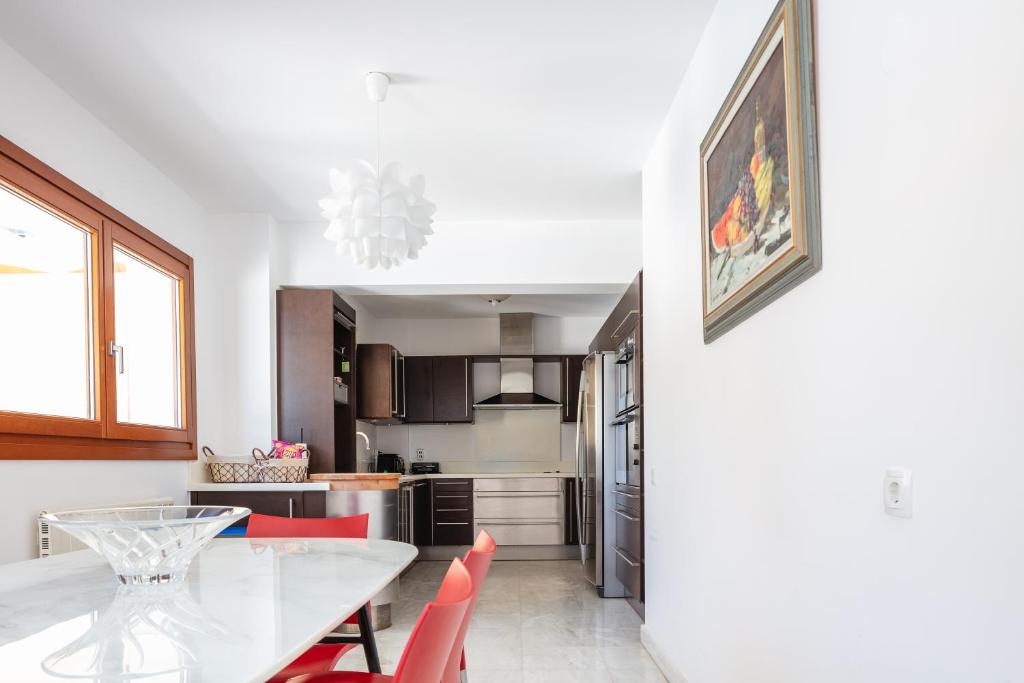 a kitchen with a dining table and red chairs at Angels Villa in Kambánion