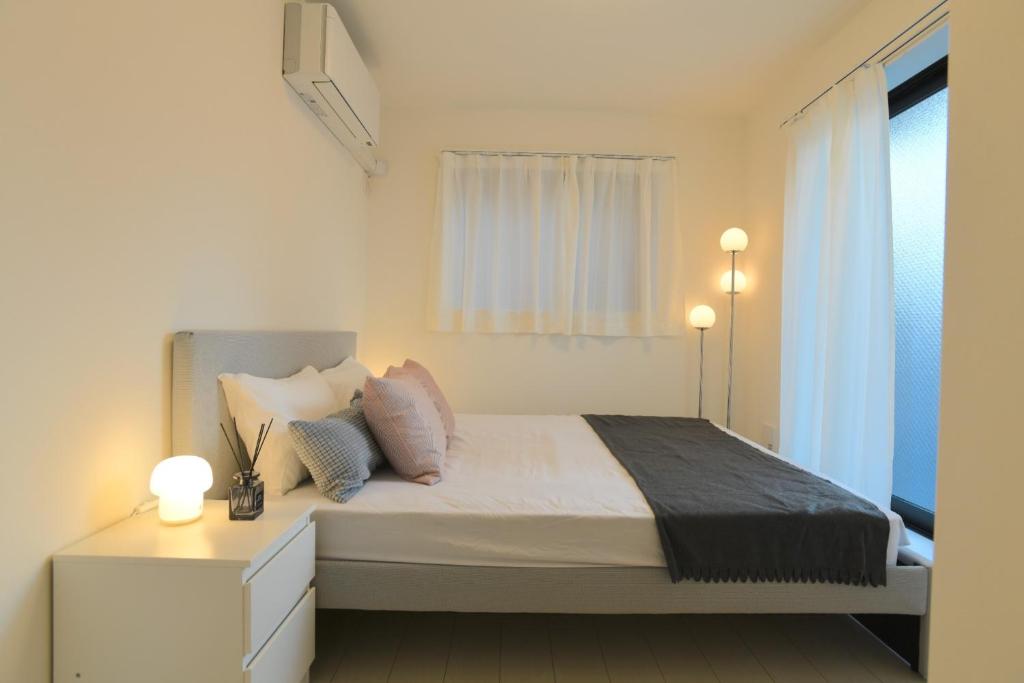 a white bedroom with a bed and a window at FL Residence The University of Tokyo II - Vacation STAY 12677 in Tokyo
