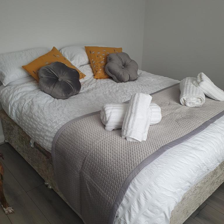Una cama con almohadas y toallas. en Canterbury Delight en Canterbury