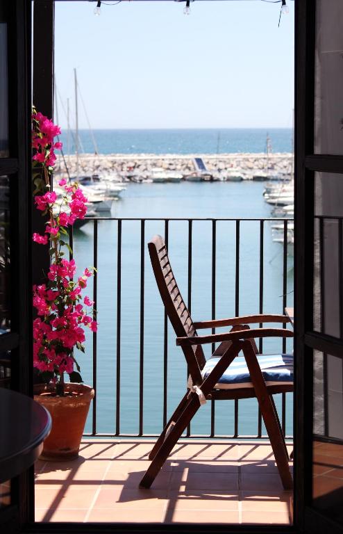 een stoel op een balkon met uitzicht op een jachthaven bij First line in Puerto Banus (Primera linea) in Marbella