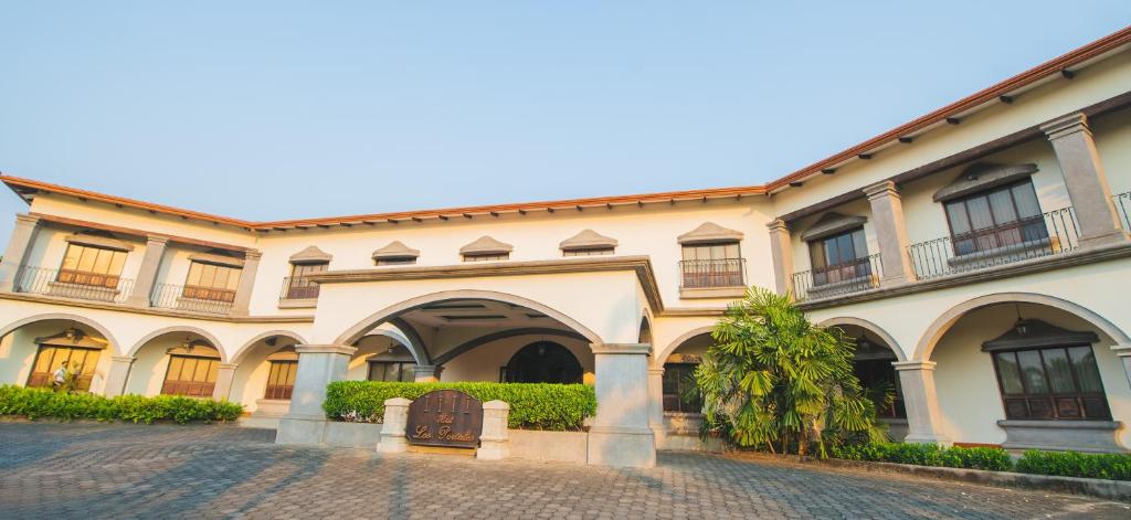 a large building with an archway in a courtyard at Hotel Los Portales in Chinandega