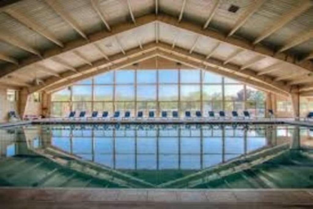 a large swimming pool with blue chairs in it at Early check in- late check out Free day! in Lake Geneva