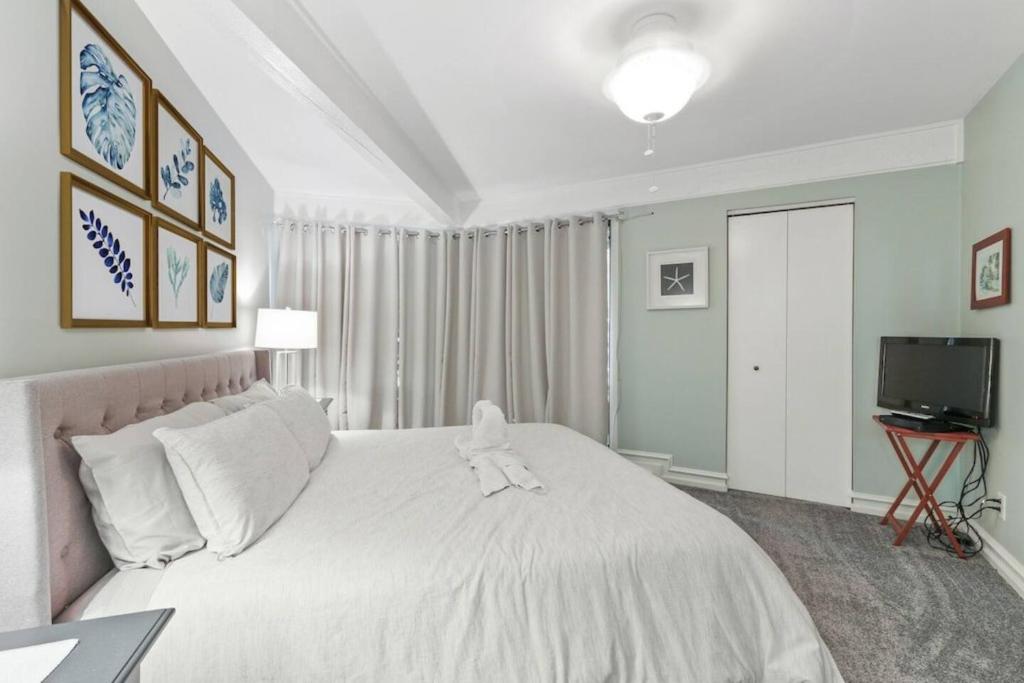 a bedroom with a white bed with a stuffed animal on it at Early check in- late check out Free day! in Lake Geneva