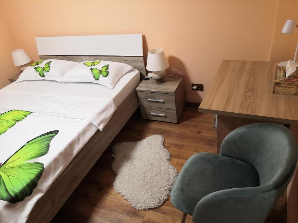 een slaapkamer met een bed, een stoel en een bureau bij Cozy central apartment in Cluj Napoca in Cluj-Napoca