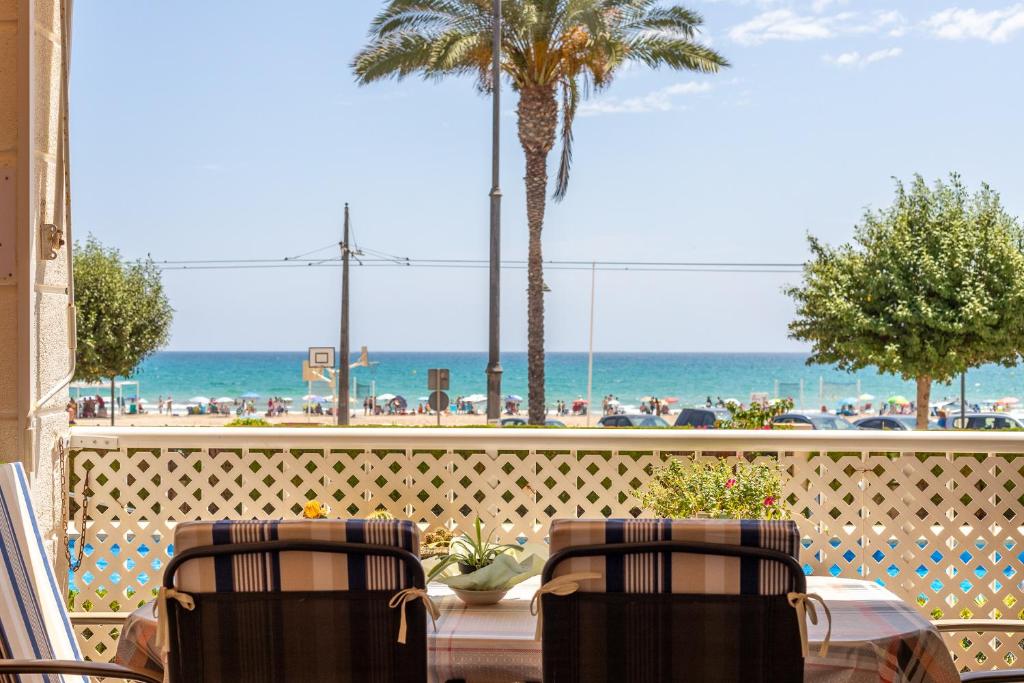 une terrasse avec une table et des chaises et la plage dans l'établissement Apartamento Columbretes, à San Juan de Alicante