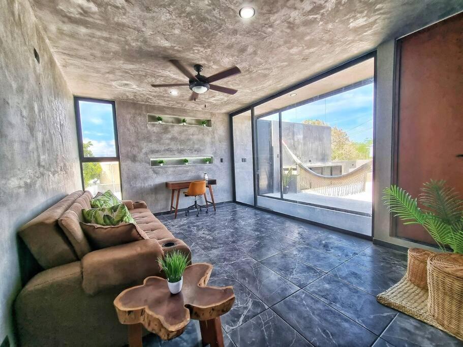 een woonkamer met een bank en een plafondventilator bij Home Rooftop Private Jacuzzi 3 Bedroom 4 Bth 120Mb in Xcanatún