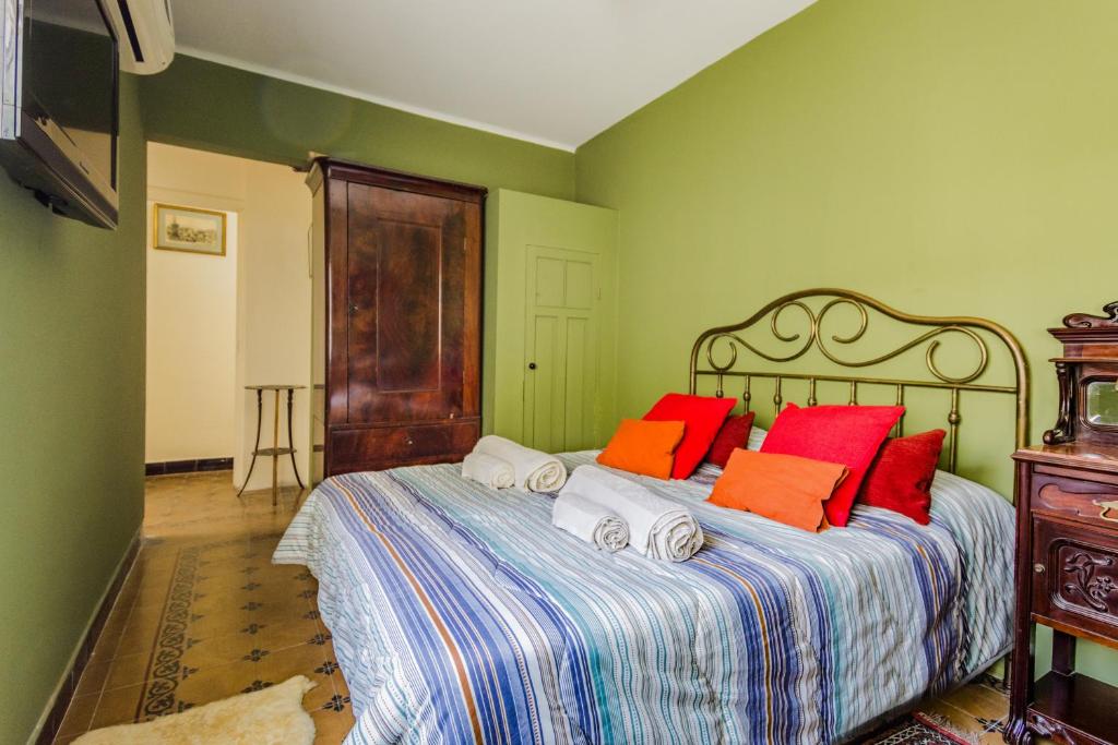 - une chambre avec un lit doté d'oreillers rouges et oranges dans l'établissement Sky Garden Sarandi [Duplex] Wild Terrace Old Town, à Montevideo