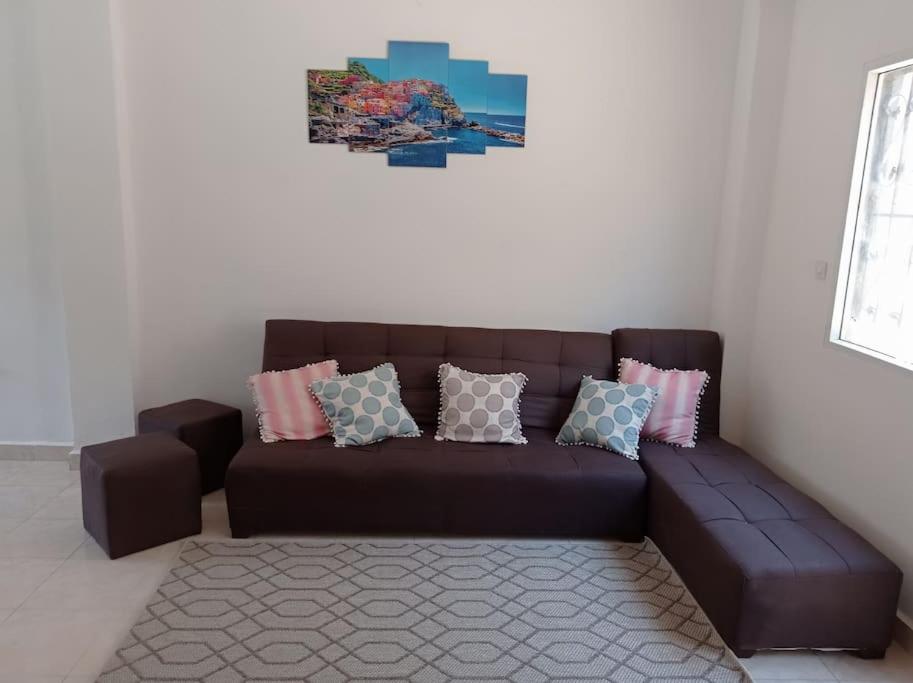 un sofá marrón con almohadas en la sala de estar en 2 bedrooms private townhouse in Zayed, en Sheikh Zayed