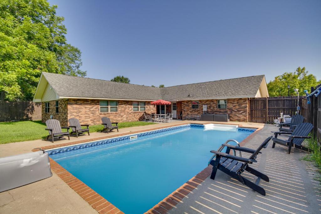 a swimming pool with chairs and a house at Inviting Gulfport Home with Private Pool and Yard in Gulfport