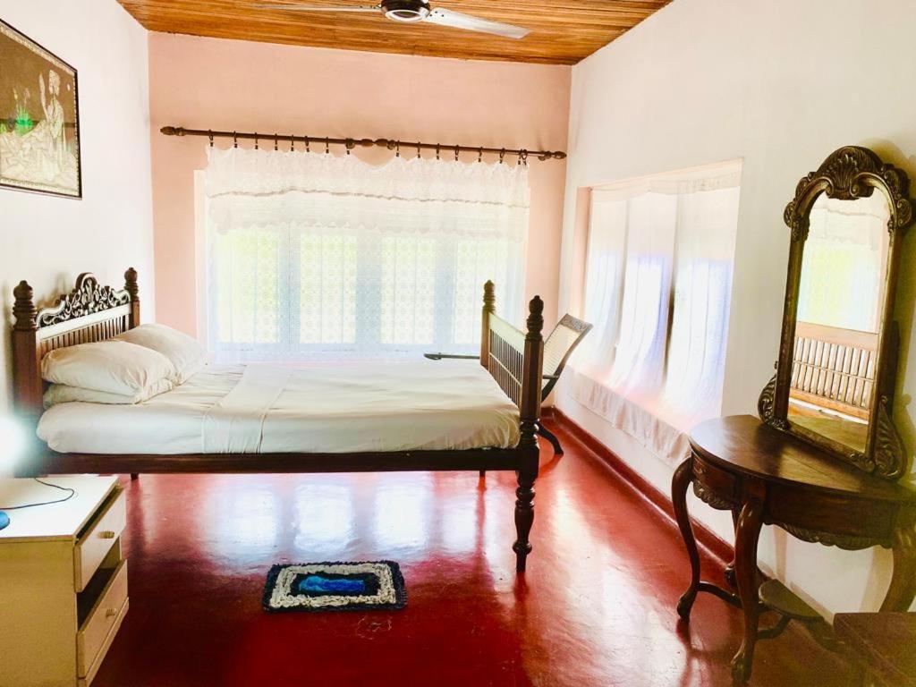 a bedroom with a bed and a table and a window at Bunkhouse in Kandy