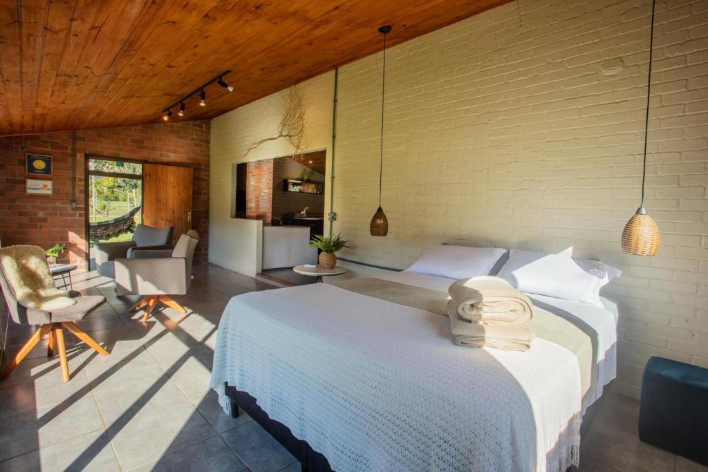 a bedroom with a large white bed in a room at Cabana no Campo Caminho do Salto Ventoso in Farroupilha
