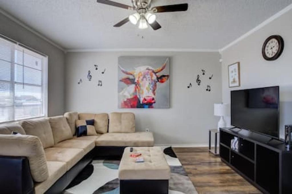 a living room with a couch and a flat screen tv at La Palma Lodge Near Texas Tech and Top Restaurants in Lubbock