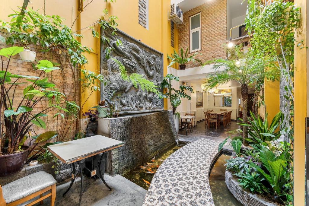 a courtyard in a building with a table and plants at Halo Hotel in Ho Chi Minh City