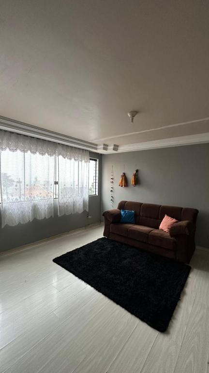 a living room with a brown couch and a rug at Apartamentos na região Central Cobertura e 2 quartos in Ponta Grossa