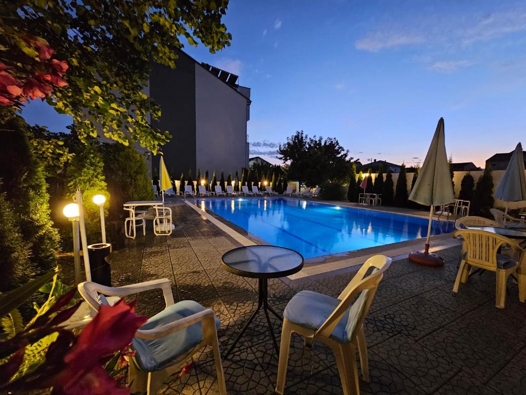 una piscina con sillas y una mesa junto a un edificio en Villa Amsterdam en Ohrid