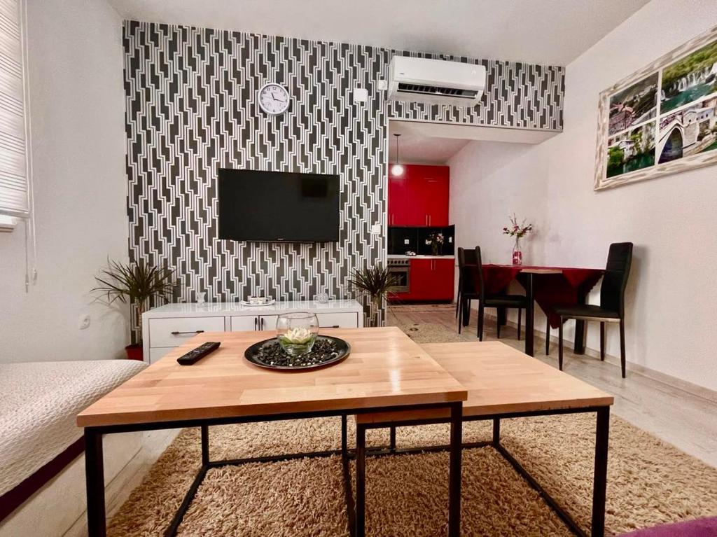 a living room with a table and a tv at Apartment Adel in Mostar