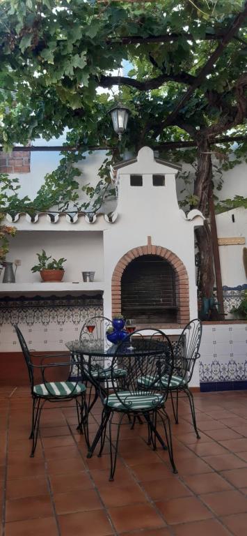 uma mesa e cadeiras em frente a uma lareira em Casa Luciíta: Agradable con chimenea, patio y BBQ. em Ojén