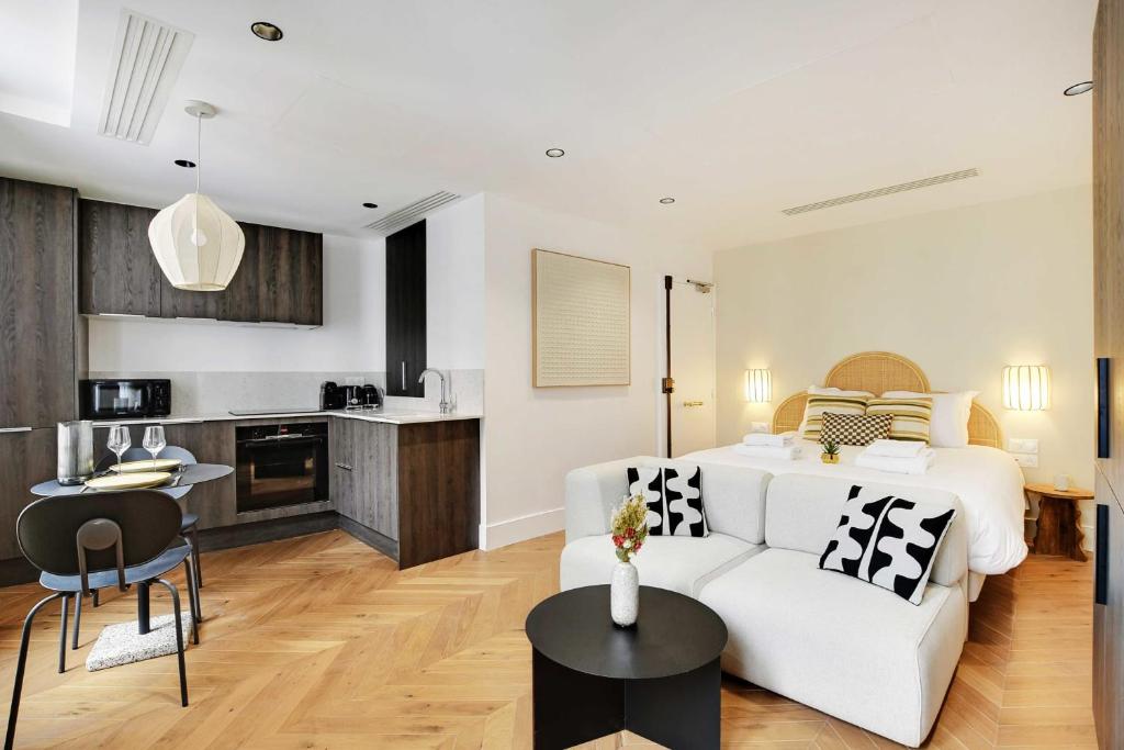 Il comprend un salon avec un canapé blanc et une cuisine. dans l'établissement Brand New Modern Studio in Central Paris - 2P - B4, à Paris