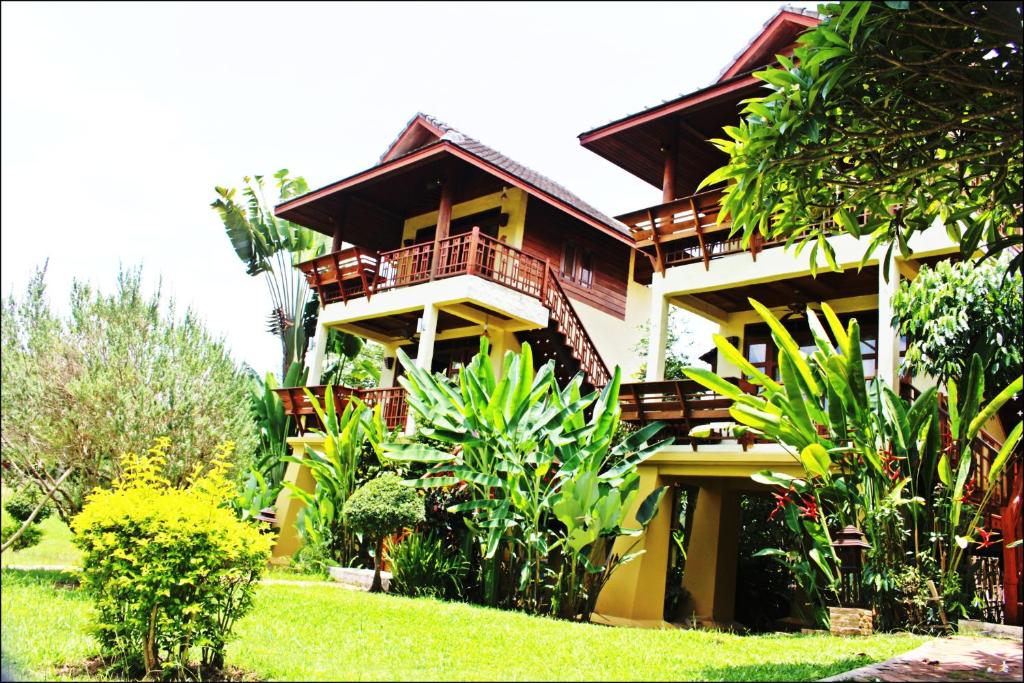 a building with a bunch of plants in front of it at Pai Vimaan Resort in Pai