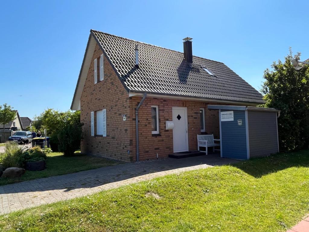 a small brick house with a small garage at Nordseejuwel in Friedrichskoog-Spitz
