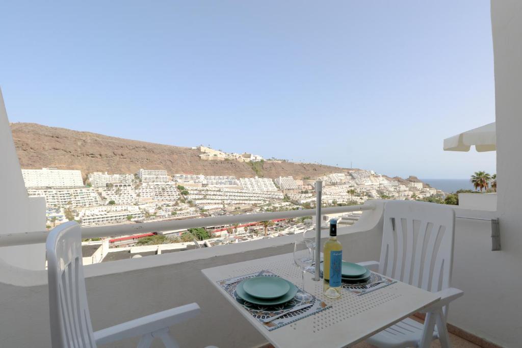 a table with a bottle of wine on a balcony at Relaxing Apartment with Ocean Views in Puerto Rico de Gran Canaria