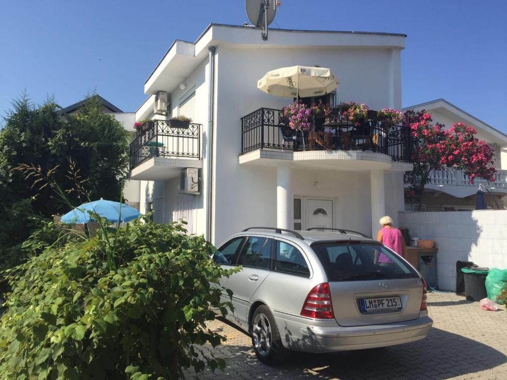 um carro estacionado em frente a uma casa branca em Nafija No1 em Donji Stoj