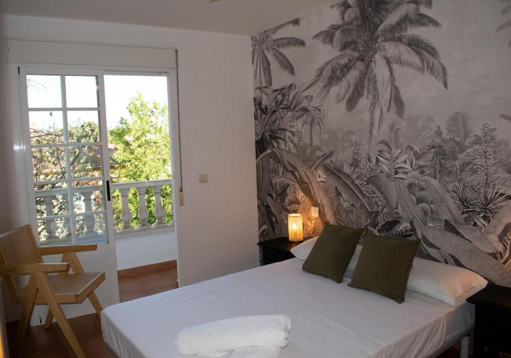 een slaapkamer met een bed met palmboombehang bij Apartamento Deluxe Candeleda in Candeleda