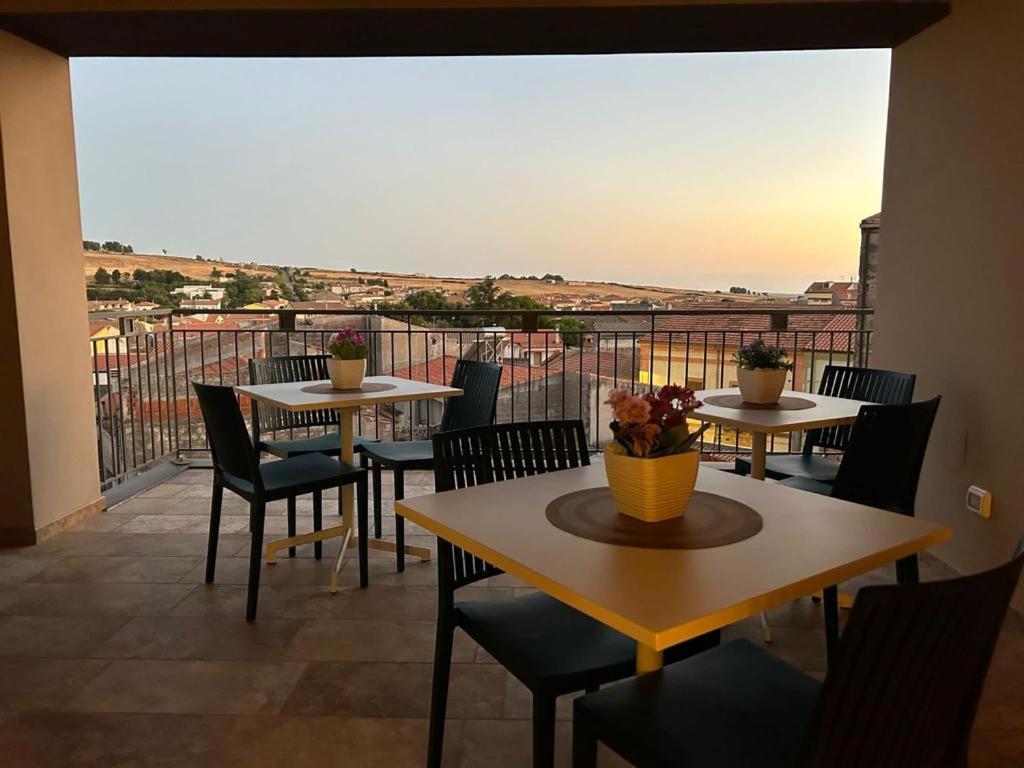 2 mesas y sillas en un balcón con vistas en Ferdinando’s House, en Pozzomaggiore