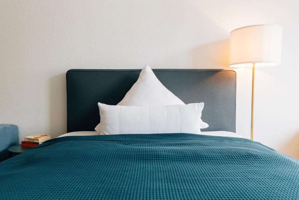 ein Bett mit weißen Kissen darüber in der Unterkunft Modernes City-Appartement in Bielefeld