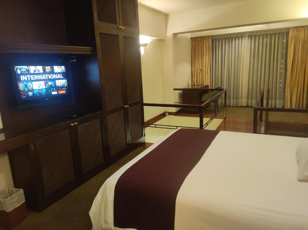 Habitación de hotel con cama y TV de pantalla plana. en Miraflores Confort Suite, en Lima