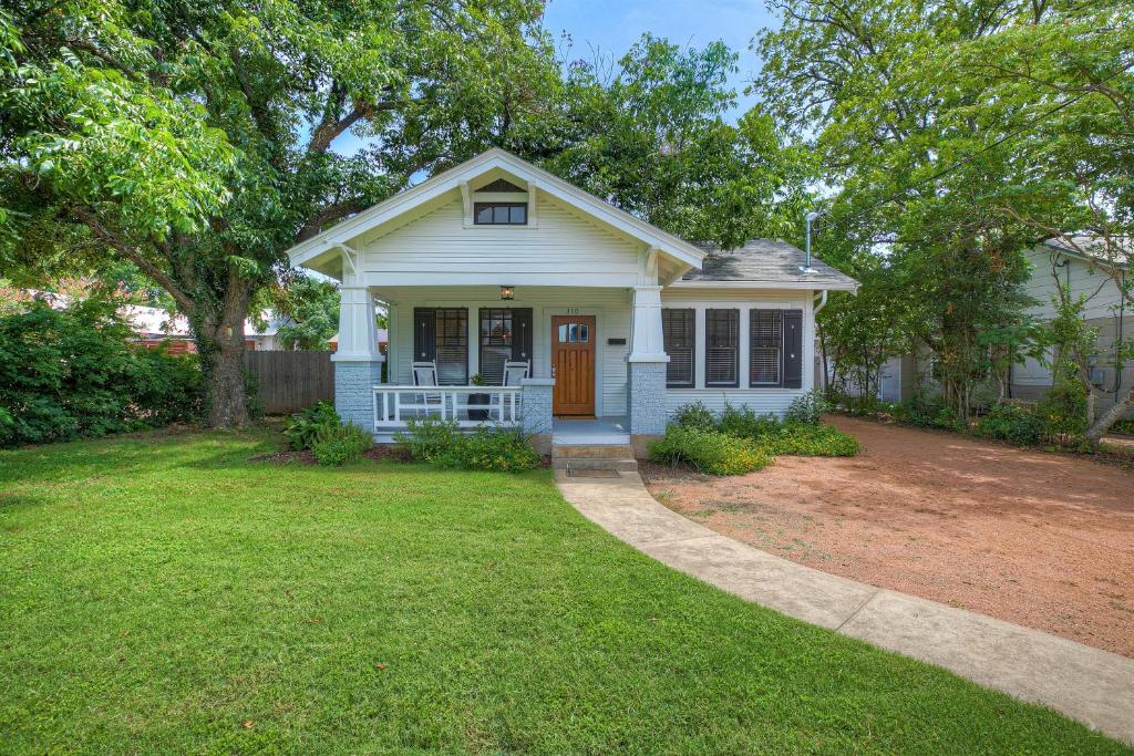 a small white house with a driveway at Luxury Combo Walk to Main with 2 Hot-Tubs in Fredericksburg