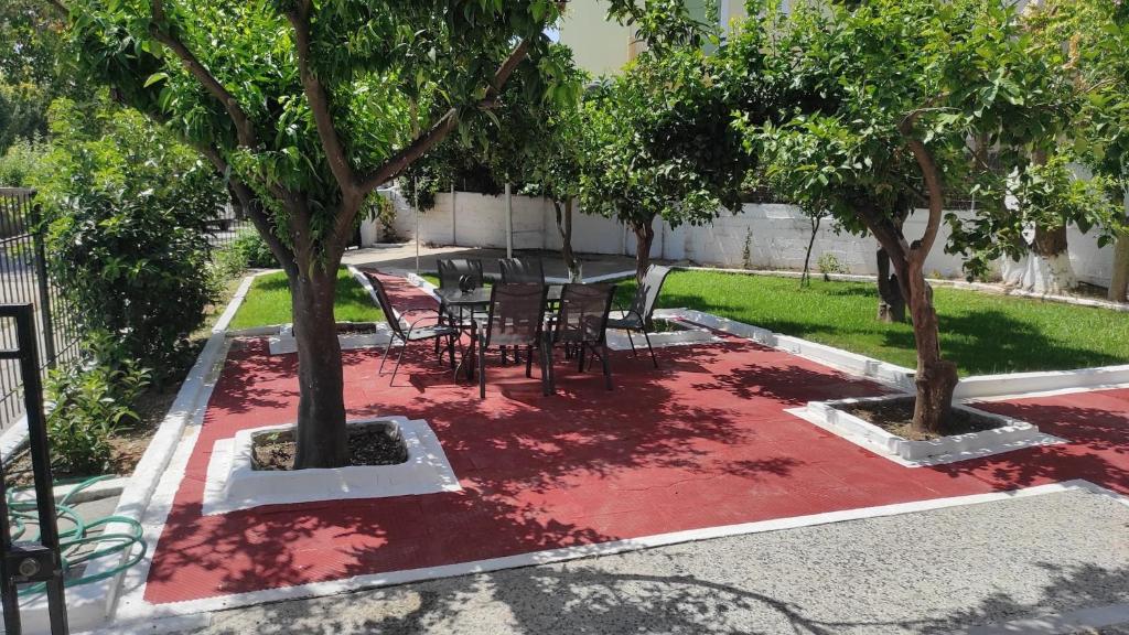 a patio with a table and chairs under two trees at City Apartment w3 BR spacious yard in Eretria