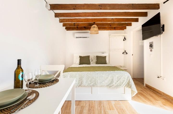 a white bedroom with a bed and a table with plates on it at Casa Azul in Granadilla de Abona