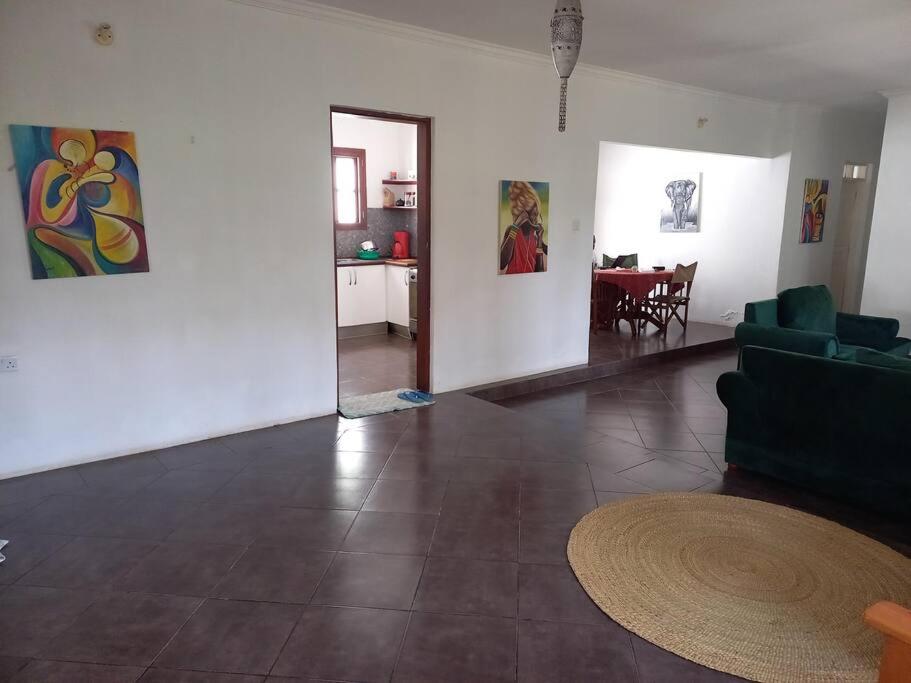 uma sala de estar com um sofá e uma sala de jantar em Evarist Mianzini House em Arusha