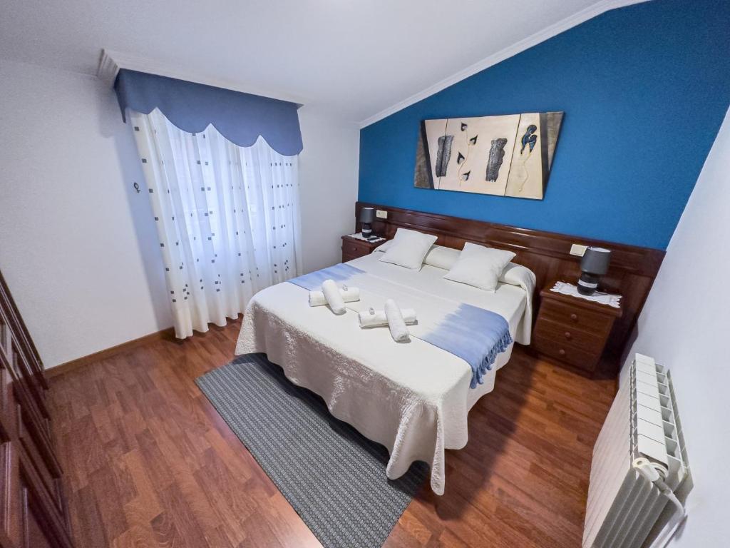 ein Schlafzimmer mit einem großen Bett und einer blauen Wand in der Unterkunft Casa Gonzalo in Arou