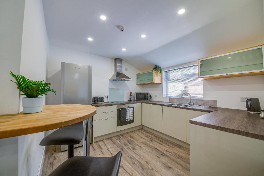 a kitchen with a wooden table and a counter top at 6bd Home-Contractors A+ Location in Sheffield