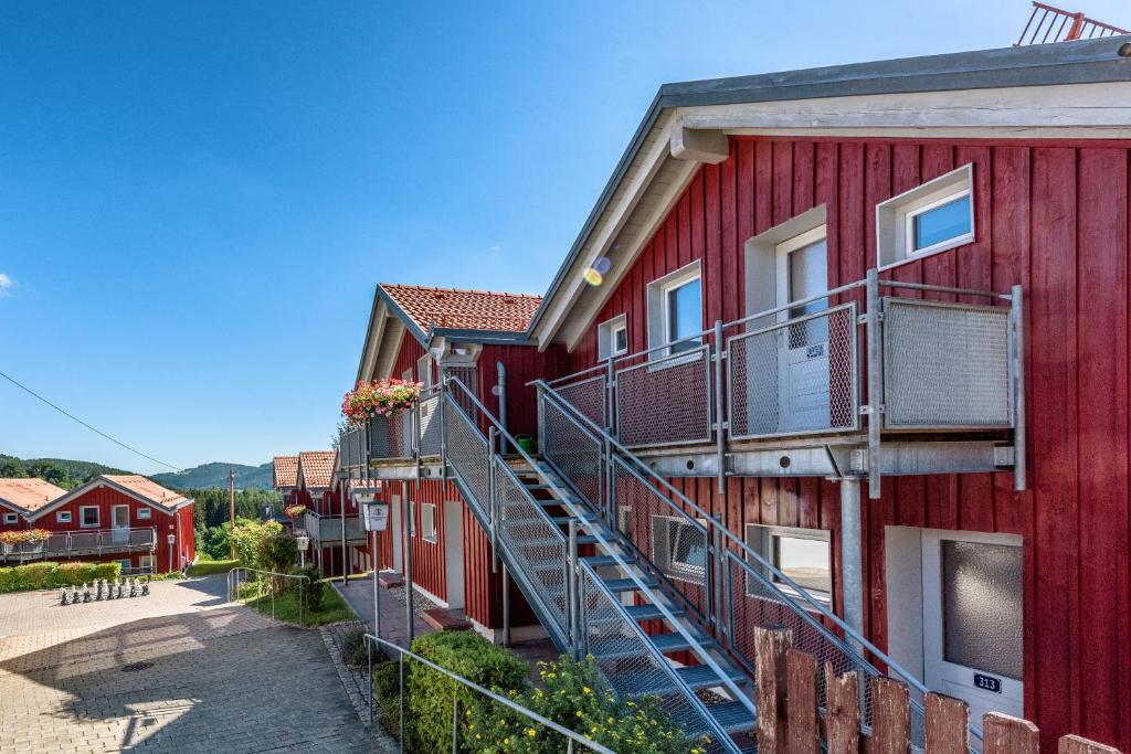 a red building with stairs next to a street at Hotel Bayerischer Wald in Neukirchen