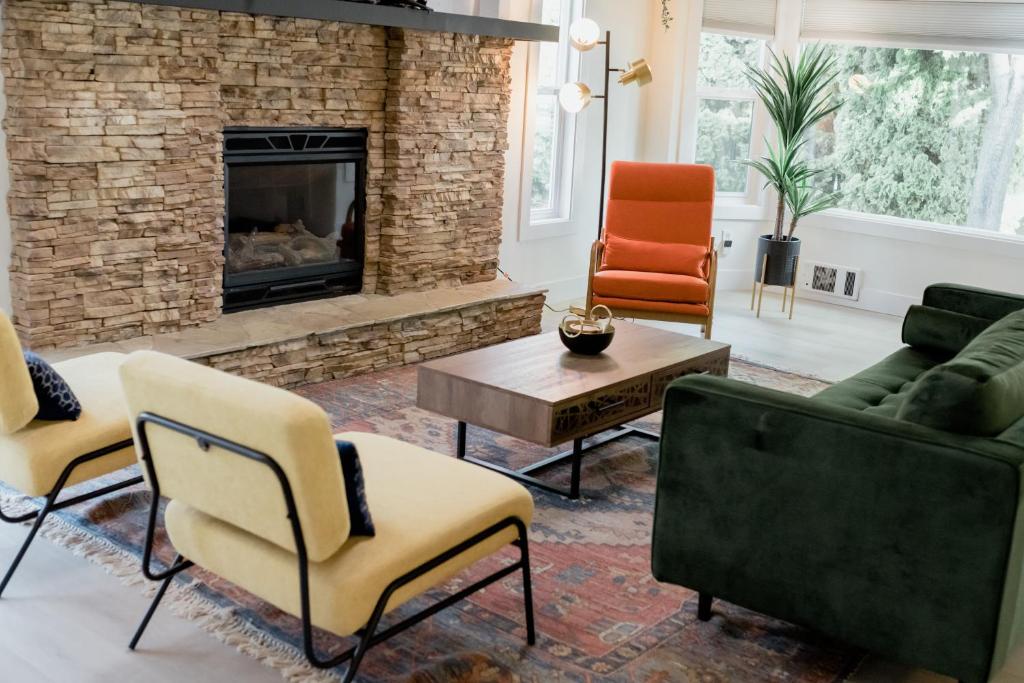 a living room with chairs and a fireplace at Charming Kelowna Haven with Hot Tub, Parking, Pet-Friendly Bliss in Kelowna