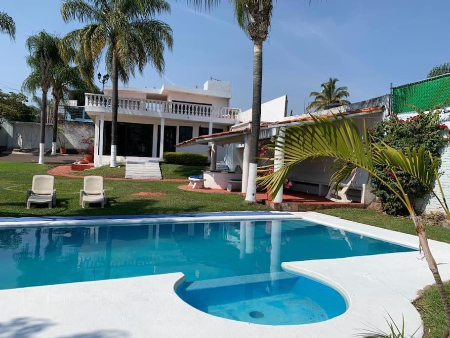 una casa con piscina di fronte a una casa di Casa para fines de semana a Cuernavaca