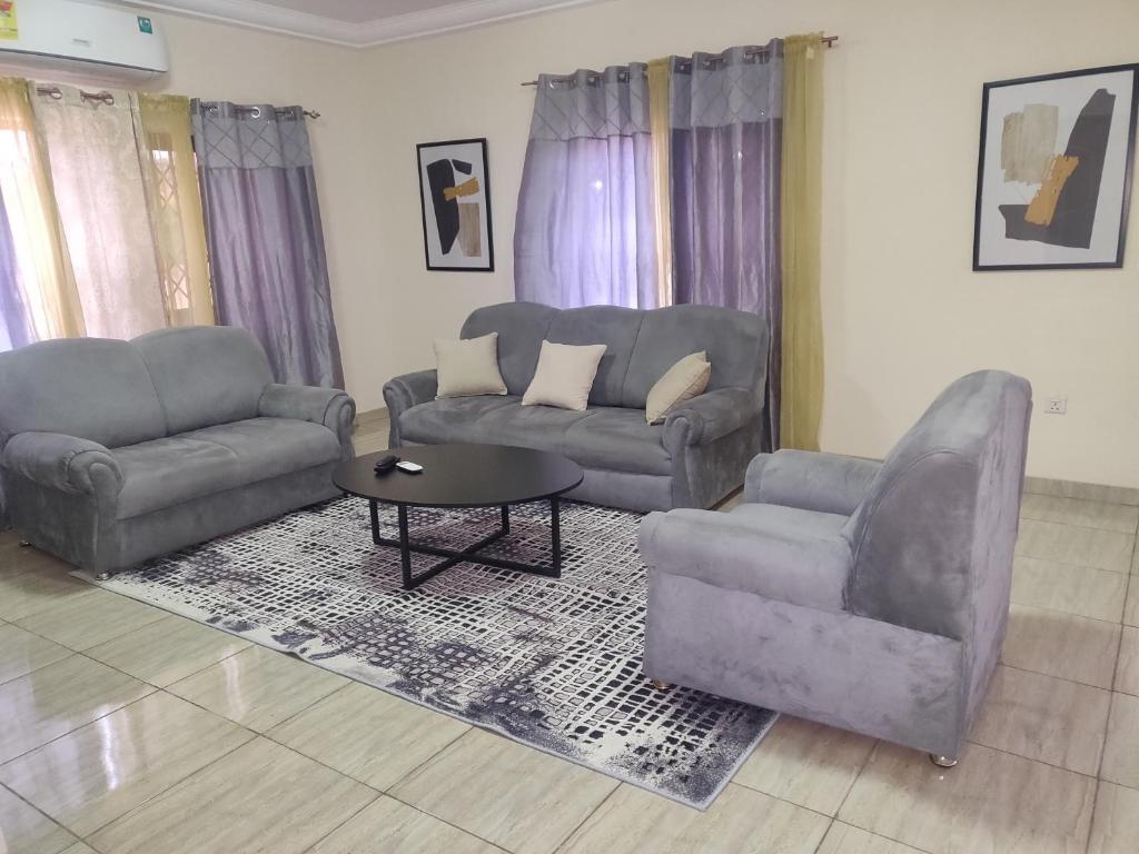 Sala de estar con 2 sofás y mesa de centro en Lakeside Lodge, en Apenkwa