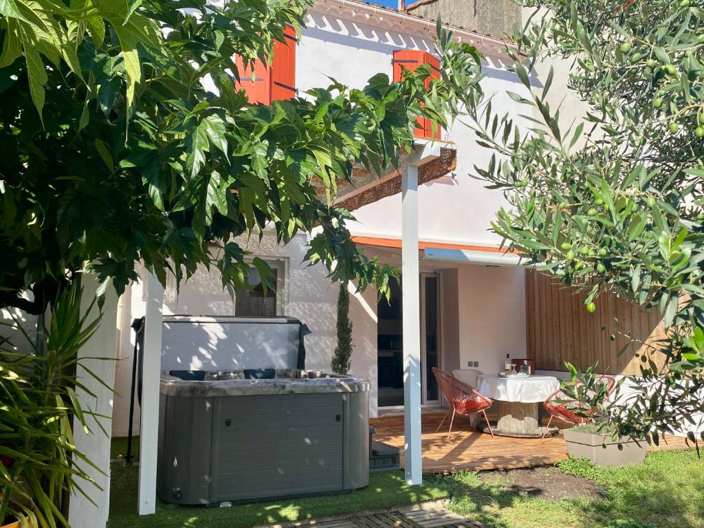 a backyard with a house with a tree at Le Céles'Thym - SPA Privatif in Conques-sur-Orbiel