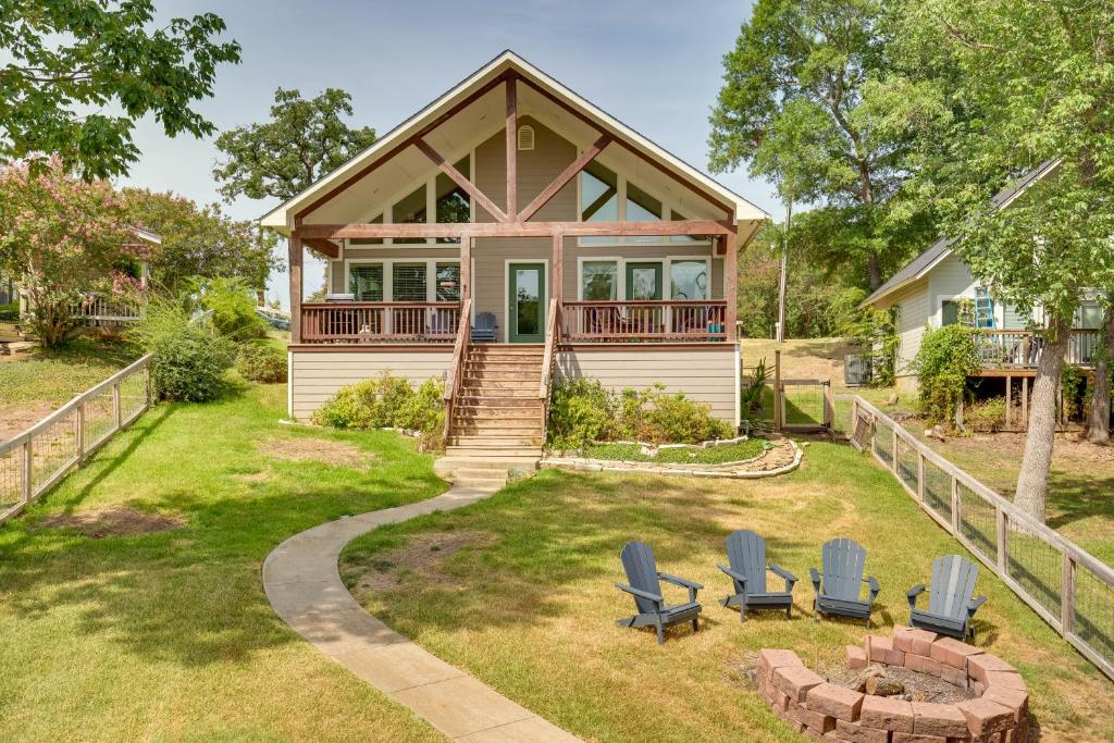 une maison avec une terrasse couverte et des chaises dans la cour dans l'établissement Tranquil Home on Cedar Creek Fish, Kayak and Unwind, à Tool