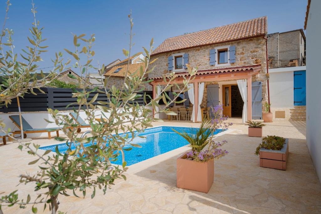a villa with a swimming pool and a house at Luxury Rustic Villa Hvar island in Vrbanj