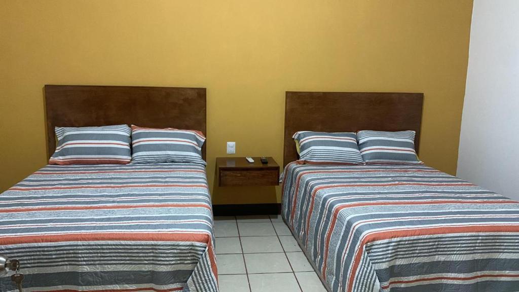 2 Betten nebeneinander in einem Zimmer in der Unterkunft Hospedaje Familiar in Tequila