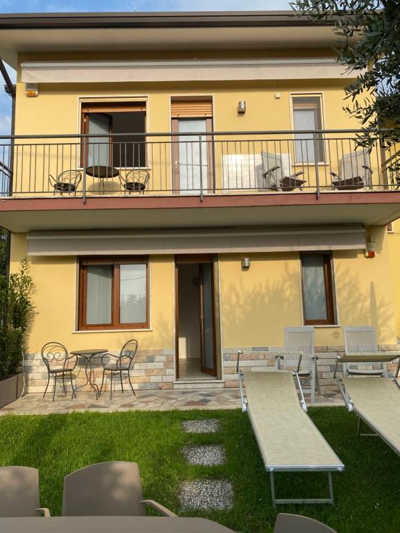 a building with tables and chairs in front of it at Appartamenti HERA in Lazise